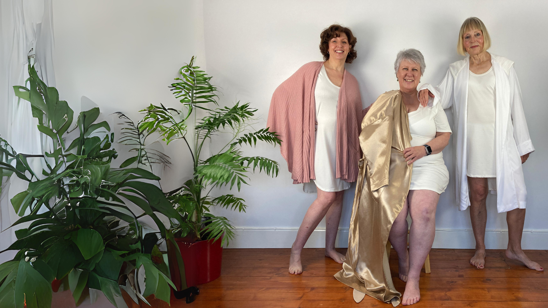 Three woman smiling at the camera wearing luxury women's sleepwear