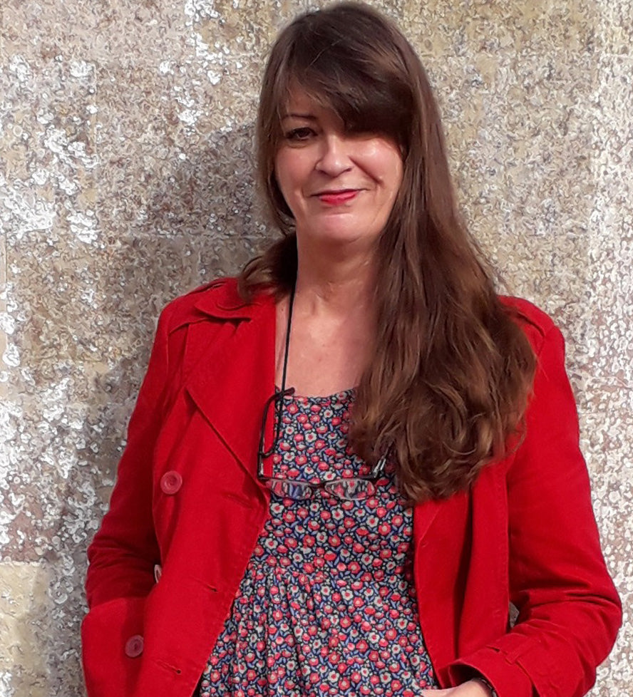 Woman smiling at camera with long brown hair and red jacket - owner of clothing brand to help with menopause hot flash symptoms