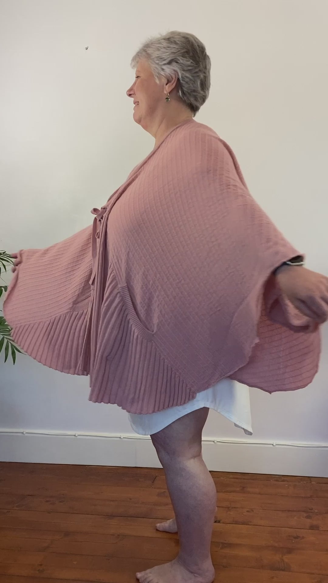 Jo turns in a circle to show off the fullness of the pink cardi-cape with front ribbing and those handy pockets. Designed for best hot flash relief